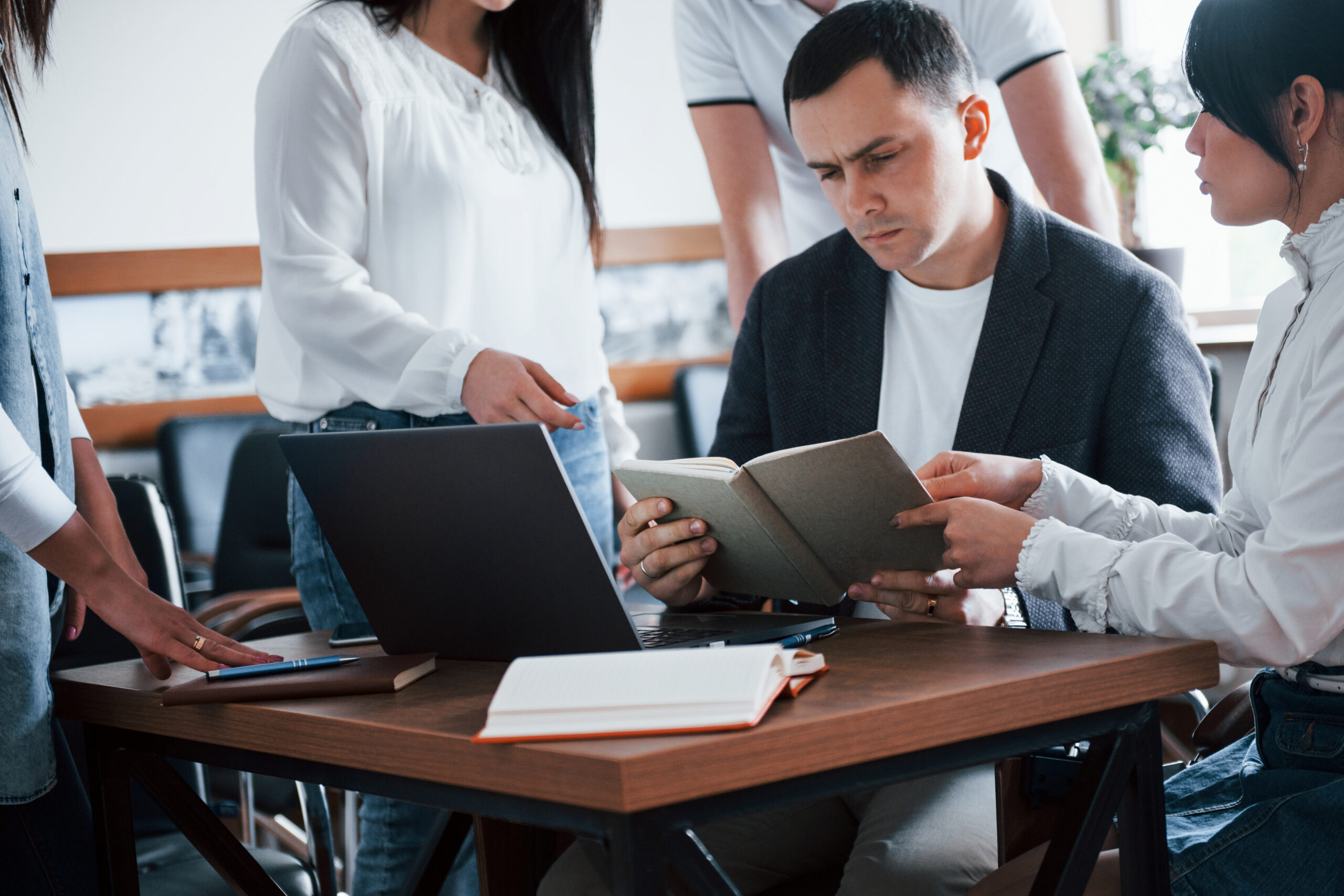 Girl explains some unclear things. Business people and manager working on their new project in classroom.